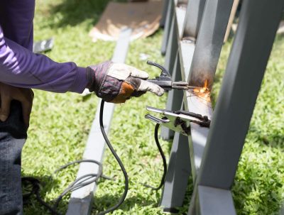 Worker welding a Steel Iron Bar for a New Fence Frame outdoor