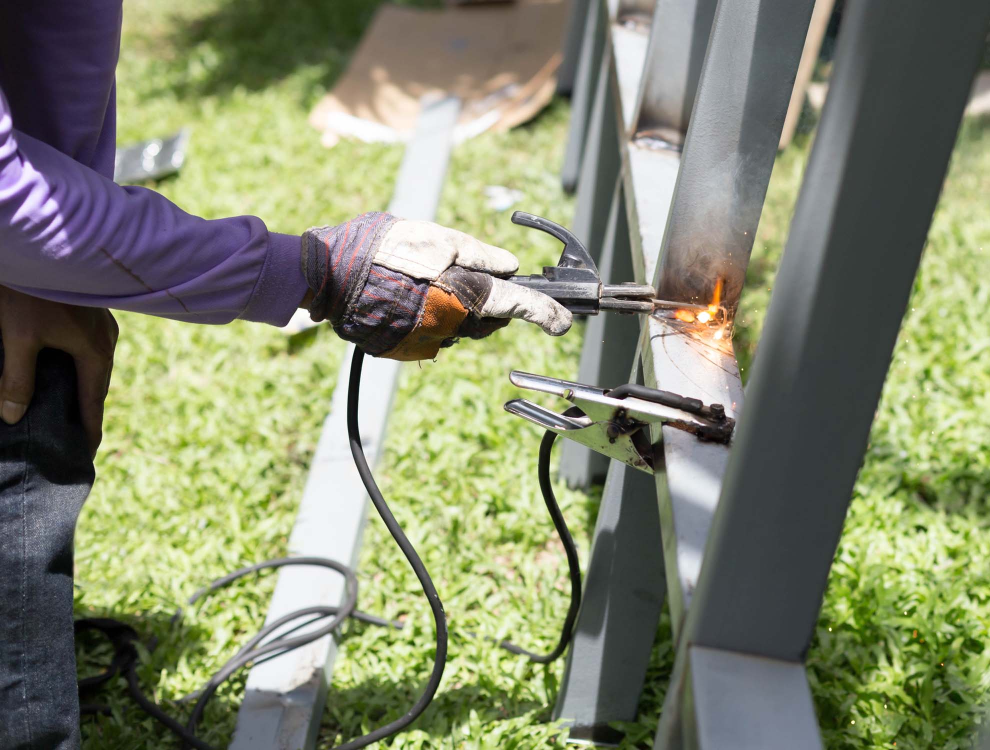 Worker welding a Steel Iron Bar for a New Fence Frame outdoor