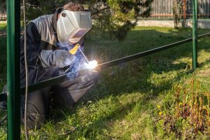 young man in a welder uniform doing welding services