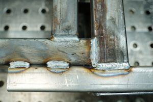 Part of workbench with group of welded metallic planks that can be used as industrial background for adverising manufactory products